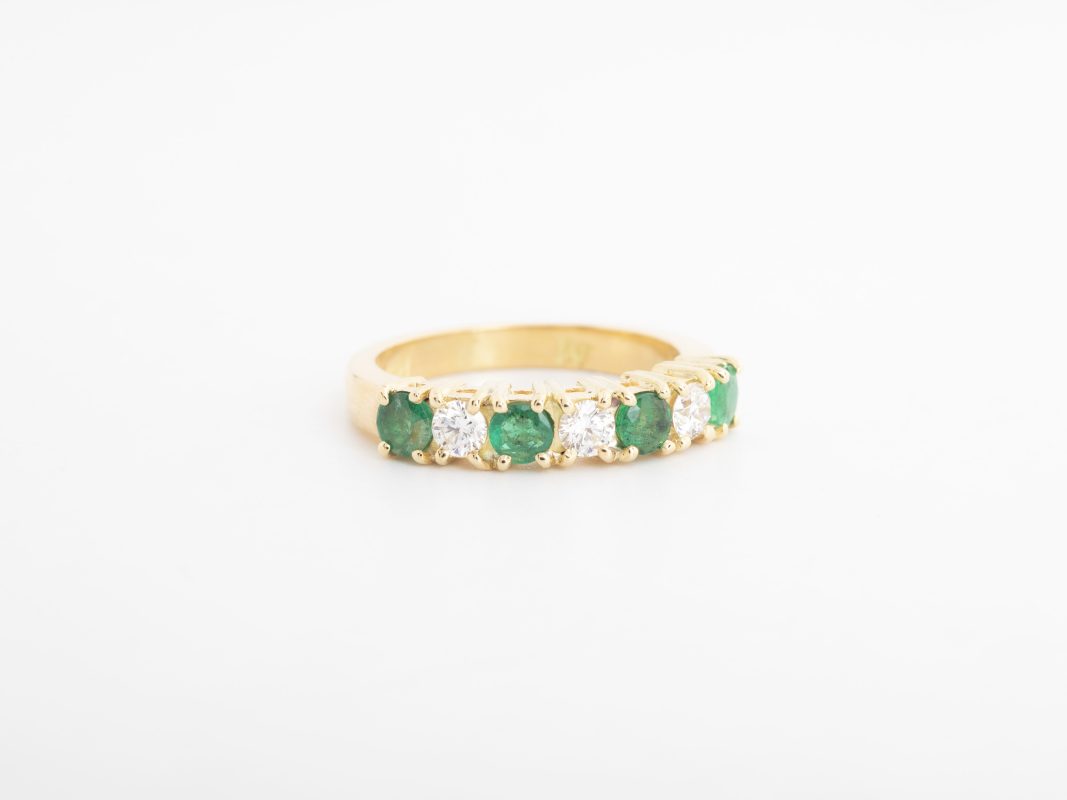 Anillo medio rivier con diamantes y esmeraldas